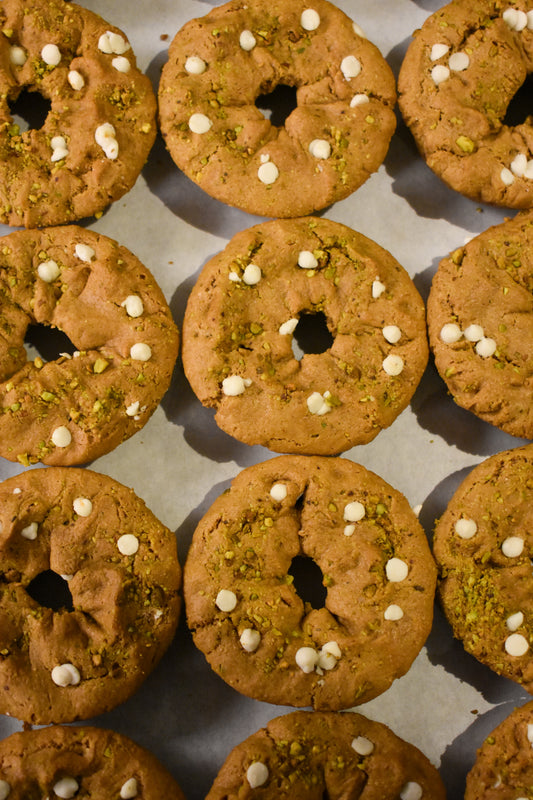 Fresh baked gluten-free pistachio cookie donut dipped in white chocolate and sprinkled with roasted pistachios - omaha nebraska 