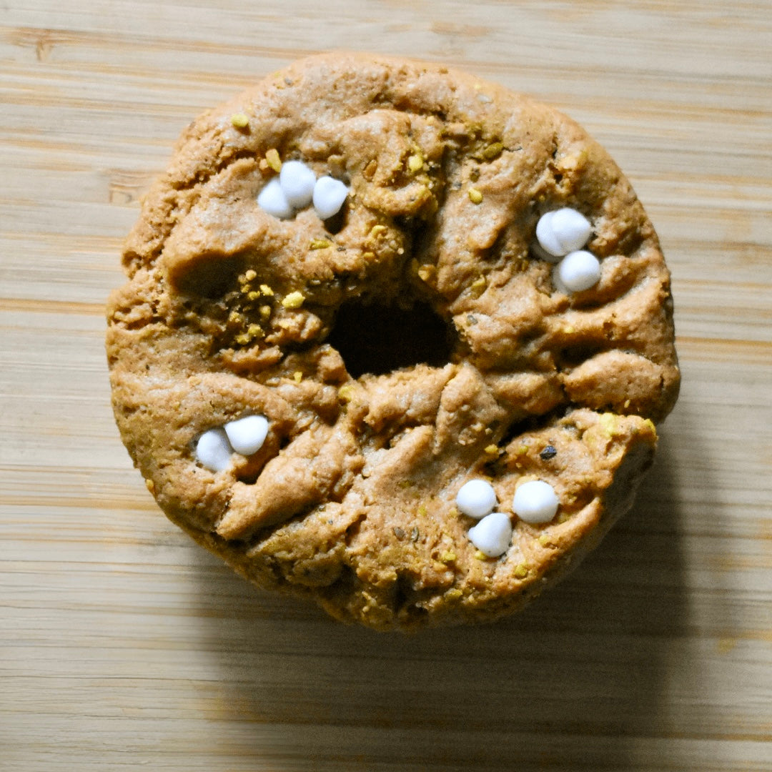Buttery Pistachio white chocolate Chip- but make it vegan! (Yasss Please!!)

Topped and hand rolled in pistachio with Enjoy Life white chocolate Chips 11g of Protein  (Vegan/Plant Based)

Gluten Free, Vegan & 12g of protein cookie-donut hybrid

Free Friday Deliveries across the Omaha metro and 14.95 shipping across the U.S. 